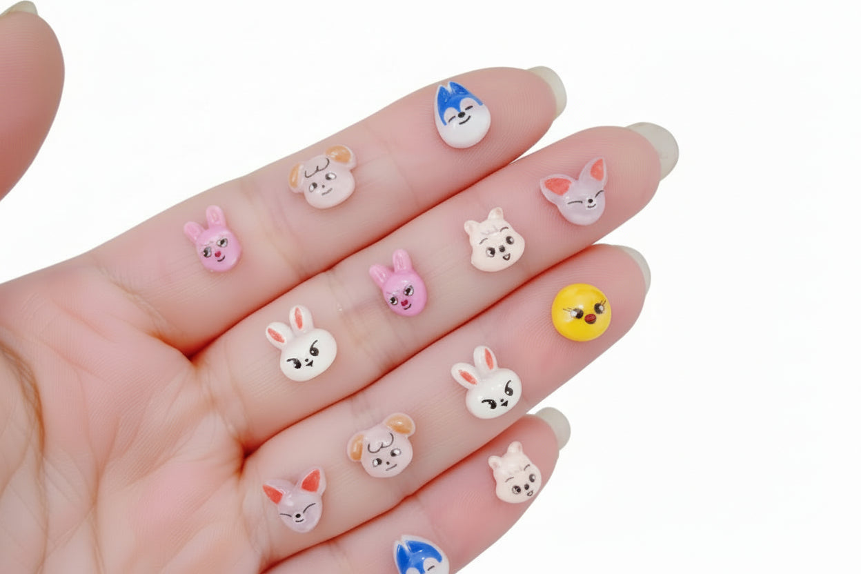 Small animal-themed nail art decorations on a hand with a colorful background