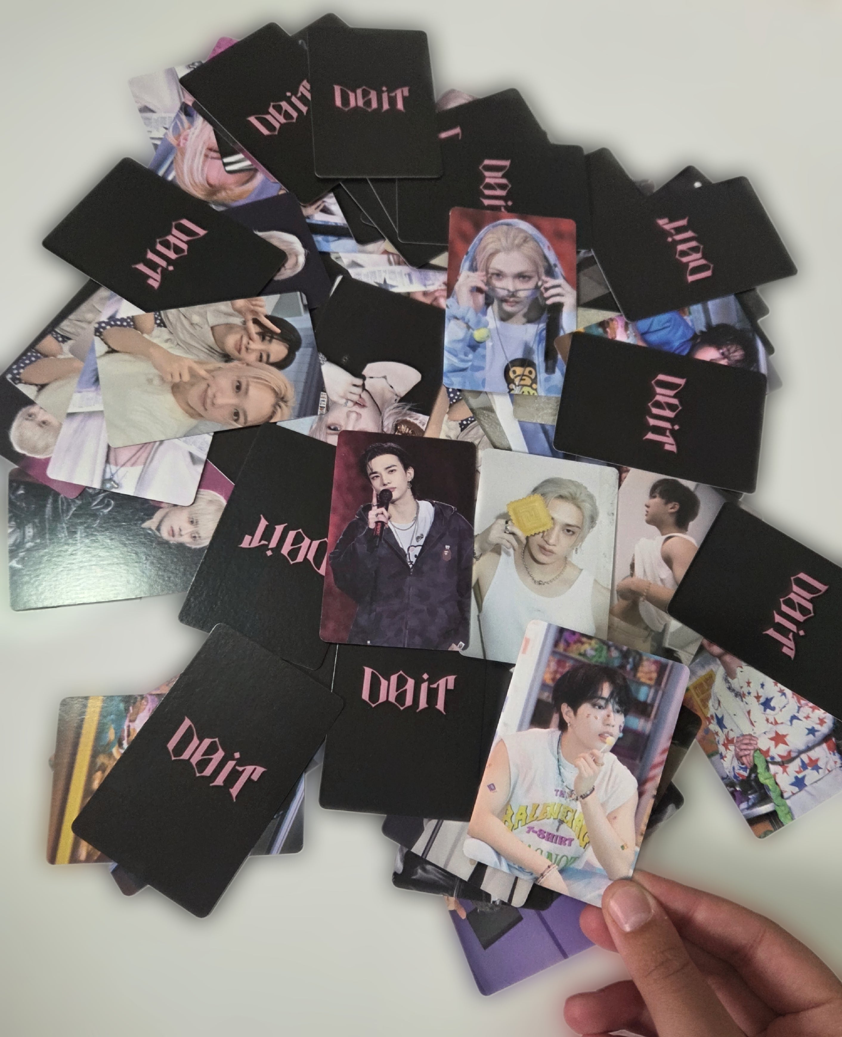 Collection of K-pop band DOIT merchandise cards on a white surface
