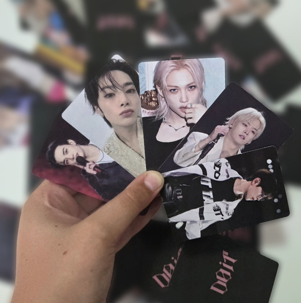 Hand holding a collection of small cards with celebrity images against a blurred background