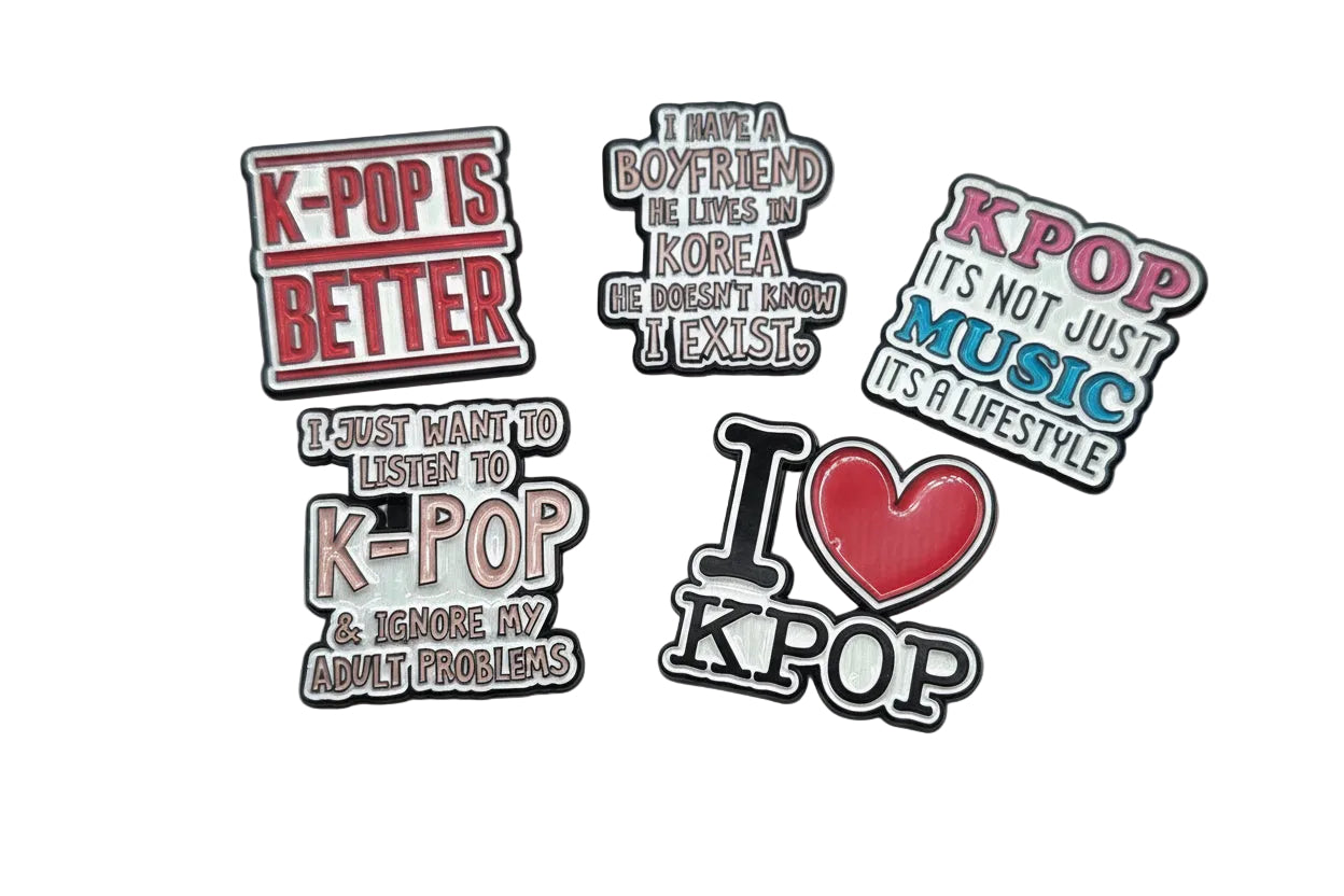 Set of K-pop themed pins with various phrases on a light gray background