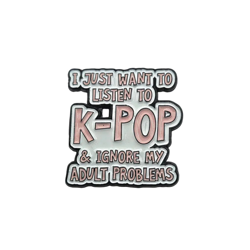 Enamel pin with text 'I just want to listen to K-POP & ignore my adult problems' on a light gray background