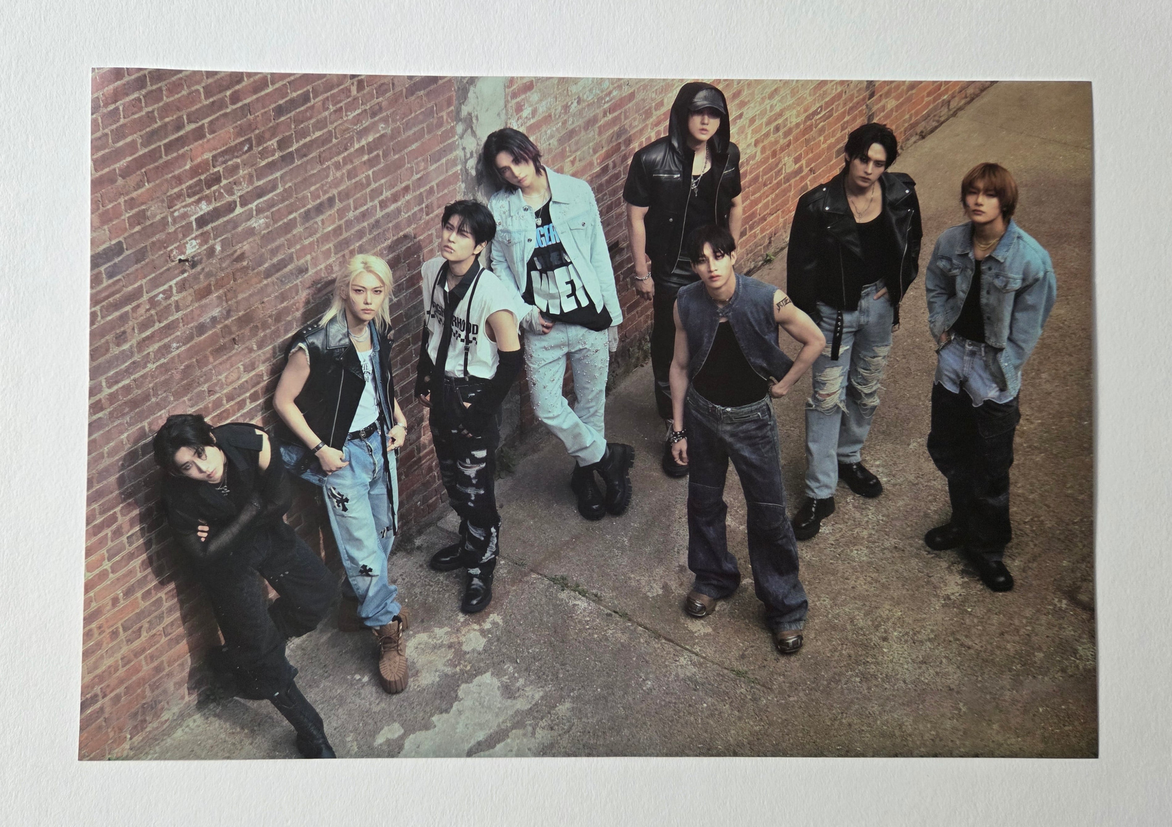 Group of people posing against a brick wall.