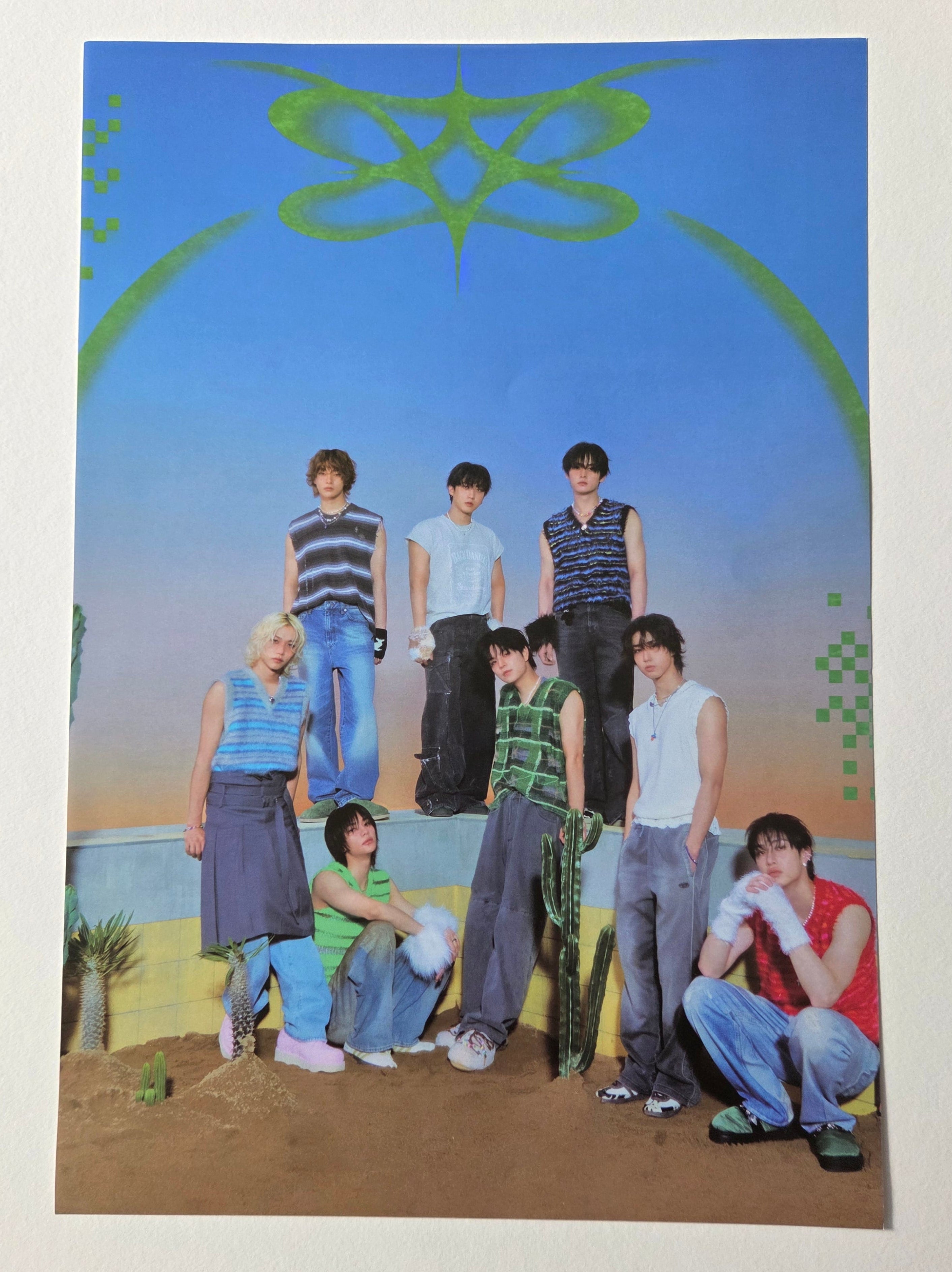 Group of people posing in front of a scenic background with a blue sky and green landscape.
