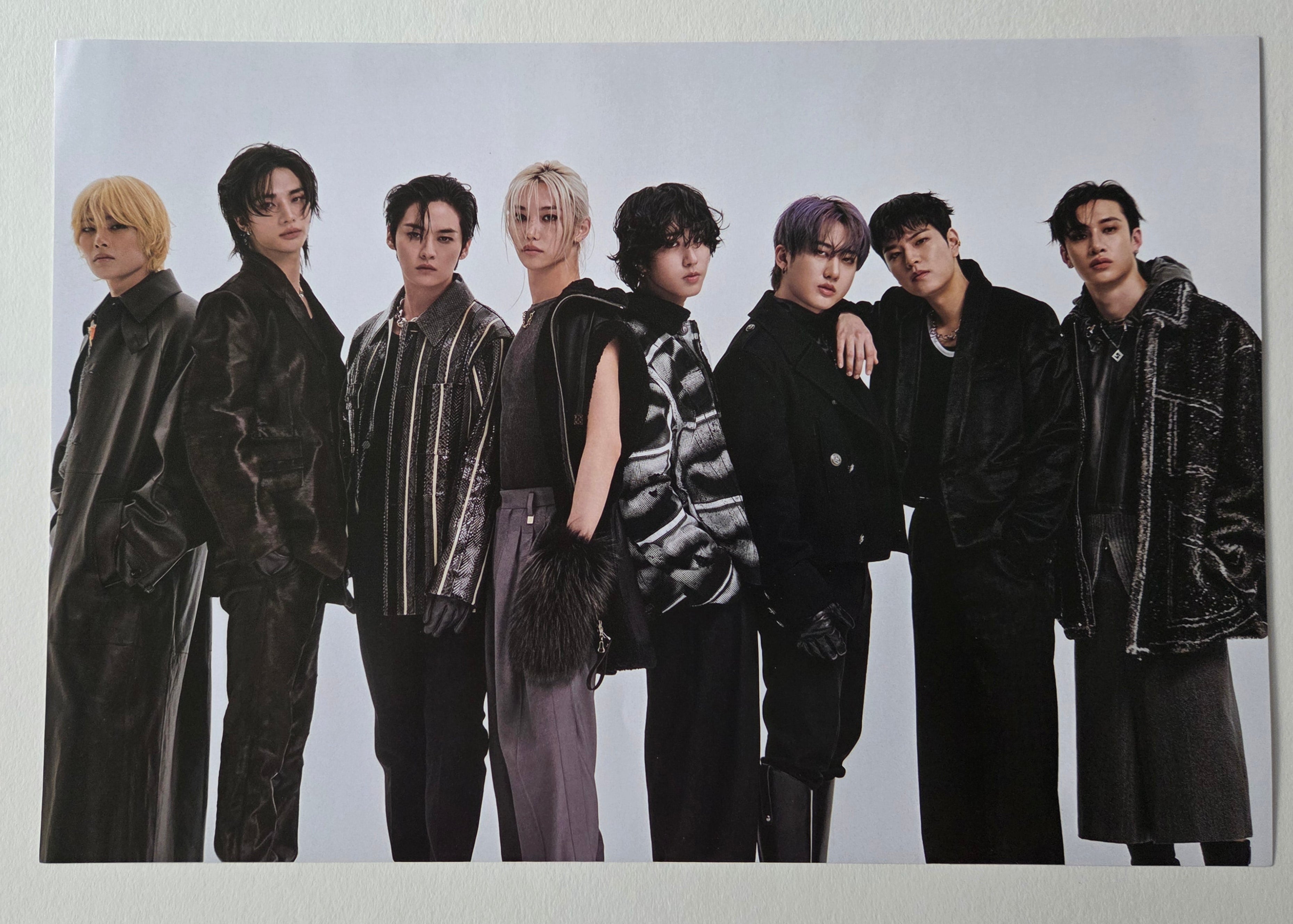 Group photo of seven individuals in formal attire on a white background